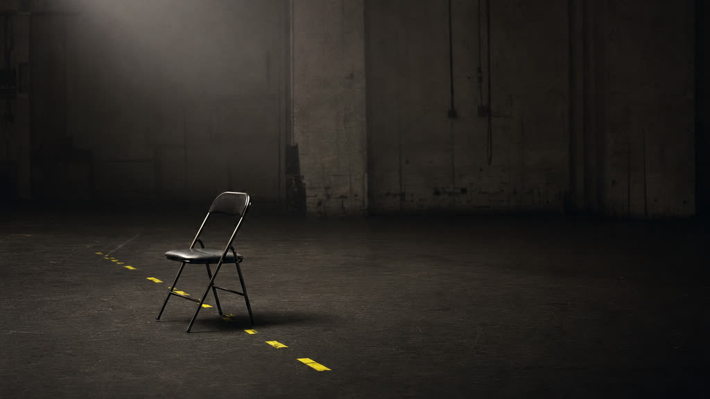 An emptied room after load-out, with faint yellow tape marks still stuck to the bare floor